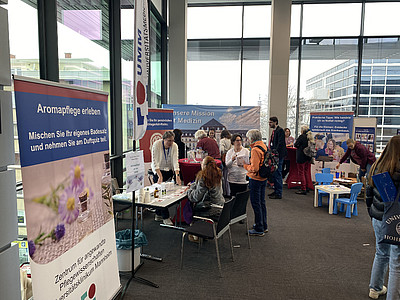 Menschen informieren sich über Aromapflege beim Neujahrsempfang.